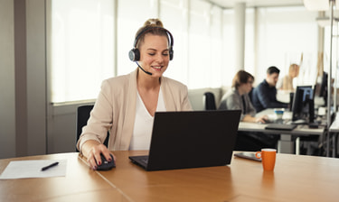 Frau mit Headset an rundem Tisch
